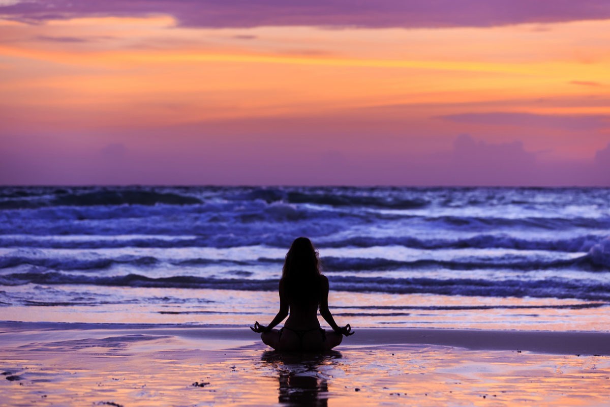 Woman meditating by the ocean