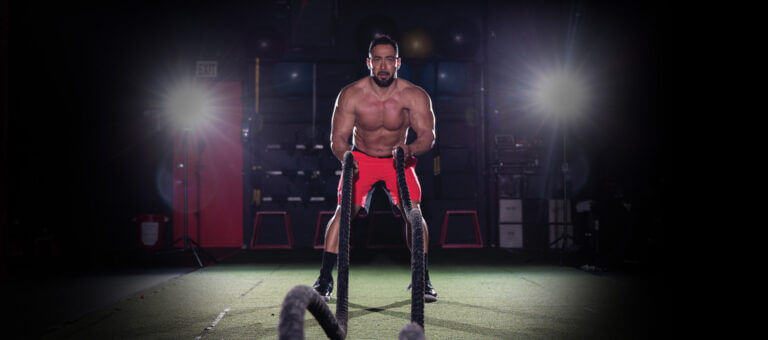 Man does battle rope workout