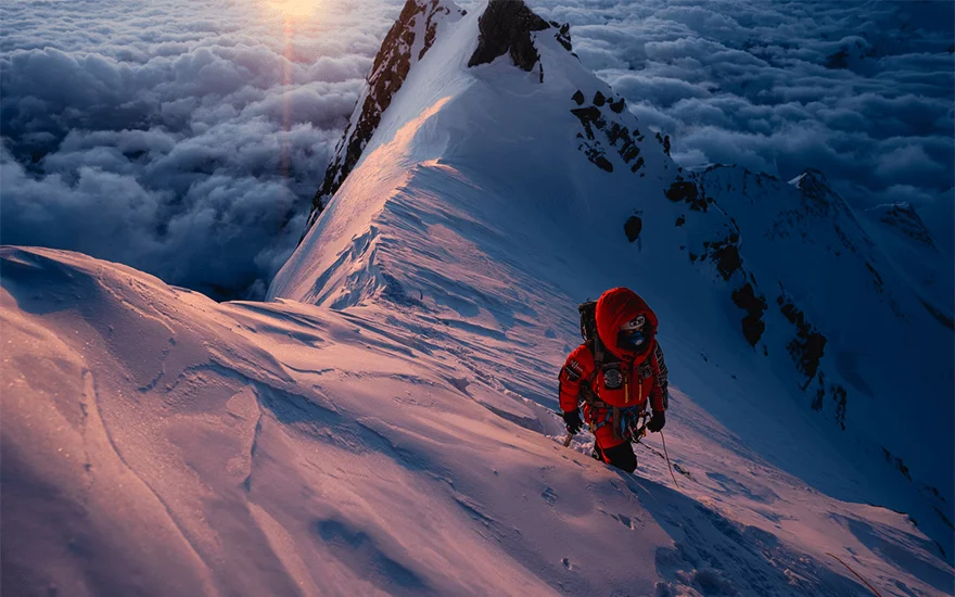 Mountain climber above the clouds
