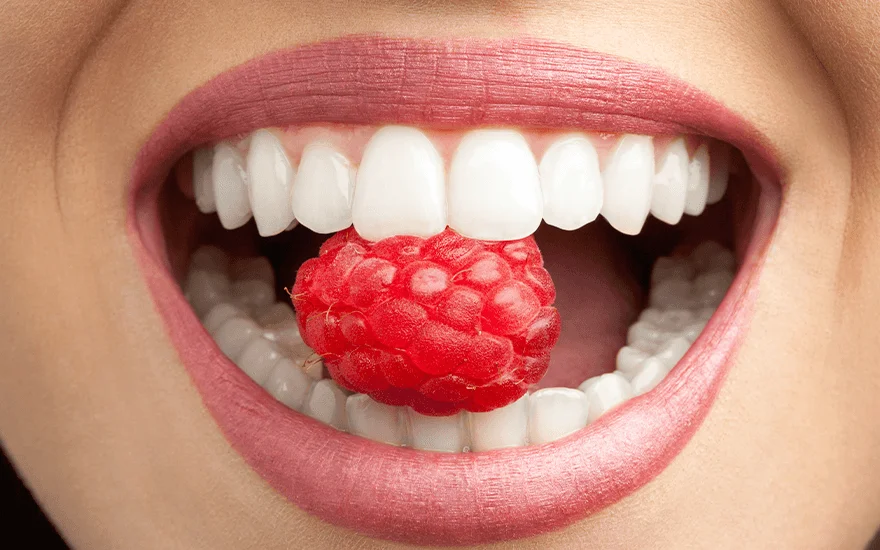 Someone eating a strawberry after seeking dental treatment in Costa Rica after engaging in medical tourism