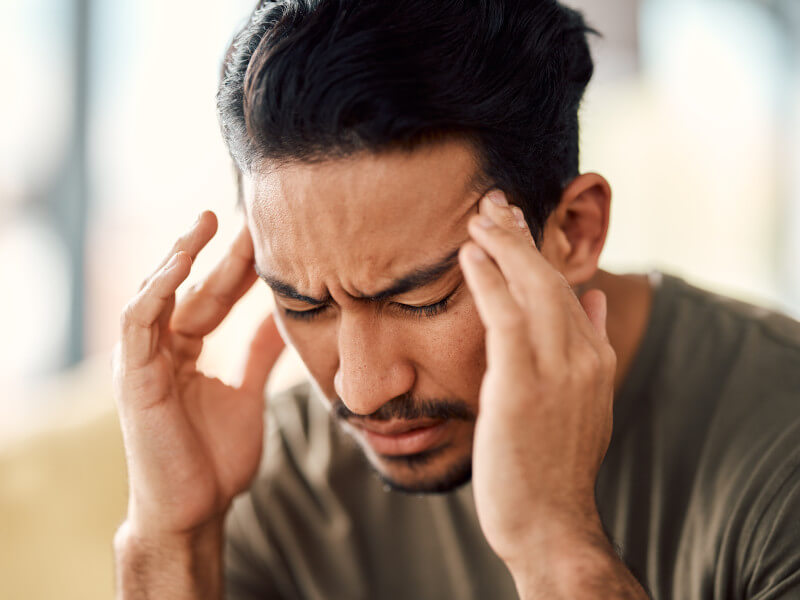 stressed man rubbing temples